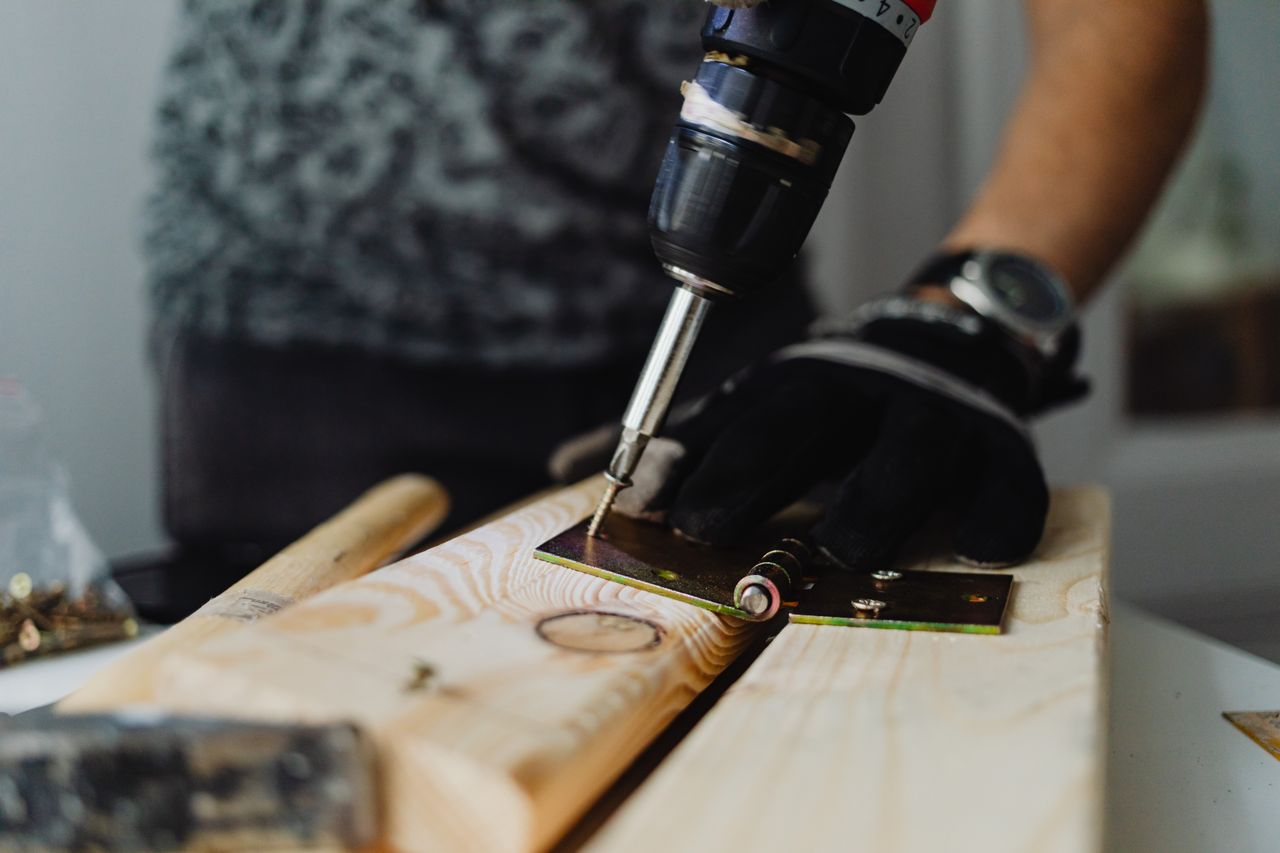 Pneumatic nail gun connected to an air compressor